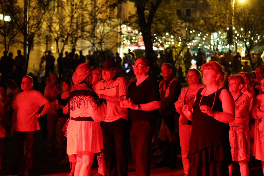 Grupa tańczy podczas wieczornej zabawy plenerowej Retro Fest.