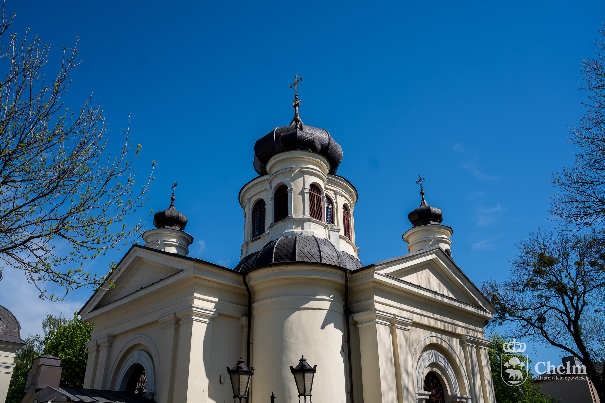 Cerkiew pw. św. Jana Teologa w Chełmie z jasną elewacją i kopułami zwieńczonymi krzyżami.