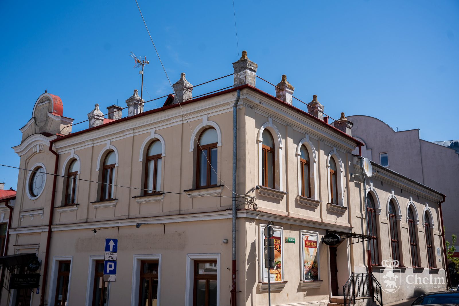 Dawna Mała Synagoga w Chełmie widoczna od strony ulicy, z jasną elewacją i arkadowymi oknami.